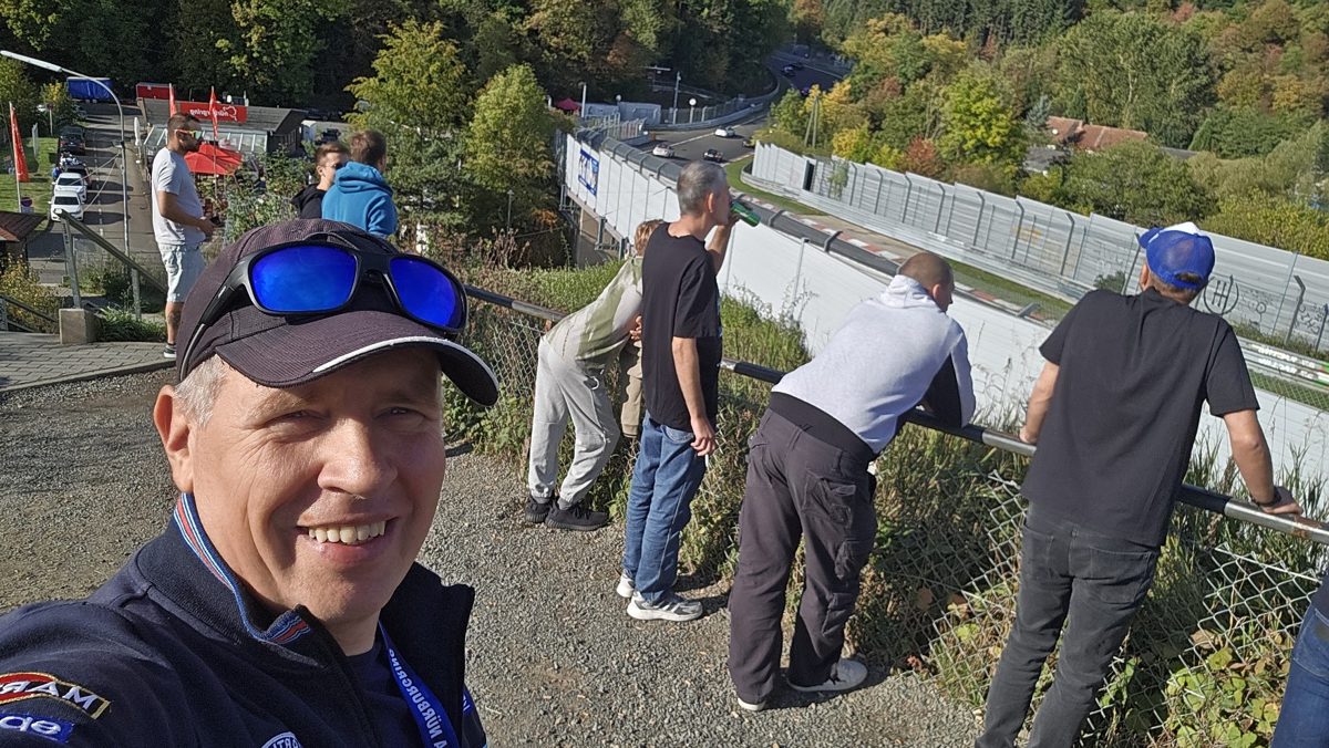 Grupa ogląda auta na torze z punktu widokowego